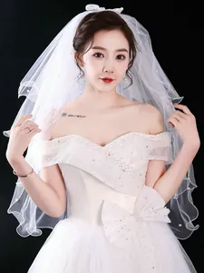 Close-up of elegant short white bridal veil with pearl accents and layered design
