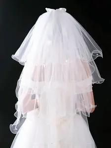 Detailed back view of an elegant white tiered bridal veil with bow and pearl accents