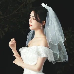 Elegant white short bridal veil with pearls and bow for wedding photography