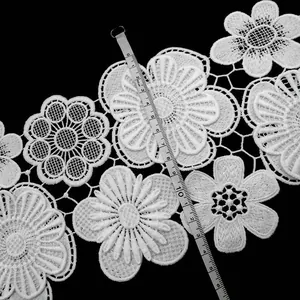 Detailed view of white milk silk floral lace trim with measuring tape showing width