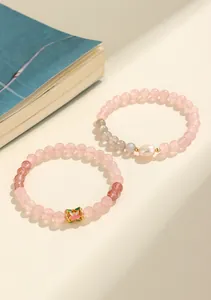 Dettaglio che mostra due bracciali in quarzo rosa e quarzo fragola con una perla