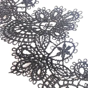 Macro detail of black water-soluble lace trim with intricate floral embroidery detail