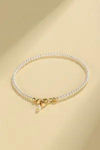Detailed view of an elegant pearl bracelet with a gold-plated spring ring clasp