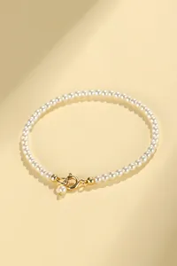Detailed view of minimalist white pearl bracelet with gold-tone spring ring clasp