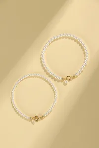 Elegant minimalist white pearl bracelet featuring a stylish gold spring clasp detail.