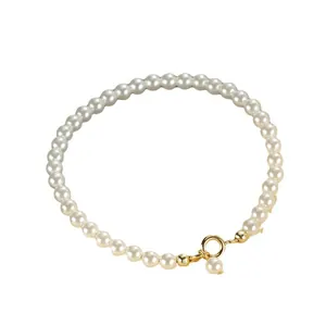 Elegant minimalist white pearl bead bracelet featuring a classic gold ring clasp design
