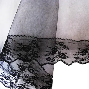 Detail of the intricate black floral lace trim on a vintage style long mesh bridal veil