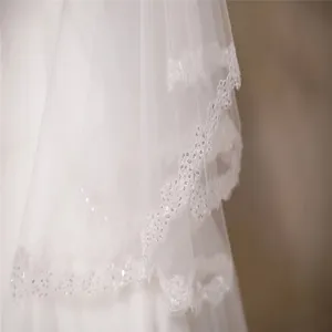 Detailed macro view of white bridal veil with elegant car-bone lace and small sequins