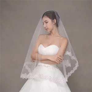 Detail view of short bridal veil featuring delicate corded lace edge and shimmering sequins