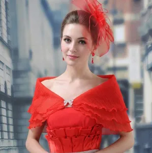 Detail of red bridal shawl with tiered chiffon layers and a rhinestone bow buckle.