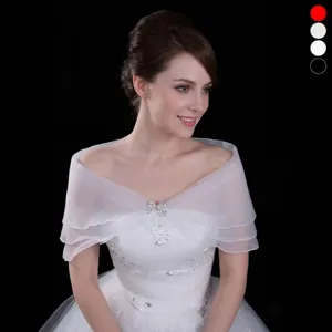 Elegant white tiered sheer bridal shawl with sparkling bow brooch closure accessory.