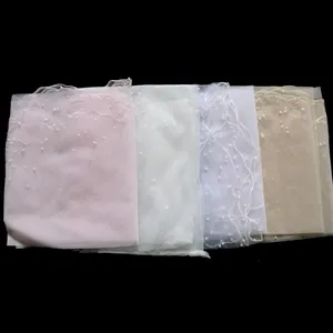 Detailed view of single-layer bridal veils with pearl accents in multiple colors