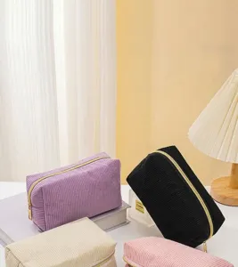 Vista dettagliata della texture in velluto a coste di alta qualità su borse cosmetiche colorate