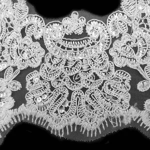 Inquadratura macro dettagliata di pizzo ricamato bianco con paillettes per cucito DIY