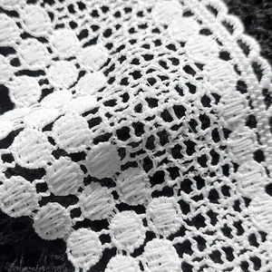 Makroaufnahme von weißer wasserlöslicher Milchseidenspitze mit feinem Stickerei-Design