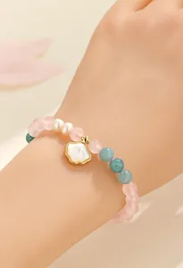 Bracciale di perle d'acqua dolce e quarzo rosa con ciondolo a conchiglia dorata.