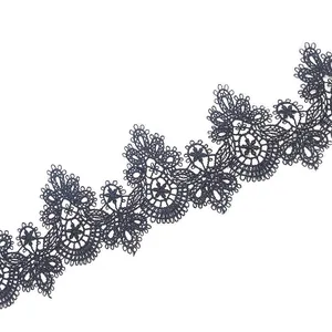 Detailed macro view of navy blue water-soluble lace trim with intricate 3D hollow embroidery