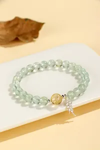 Close-up of elegant prehnite beaded bracelet with citrine bead and silver wheat charm
