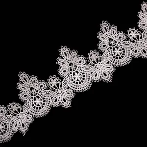 Detailed view of intricate white water-soluble lace trim with 3D hollow embroidery