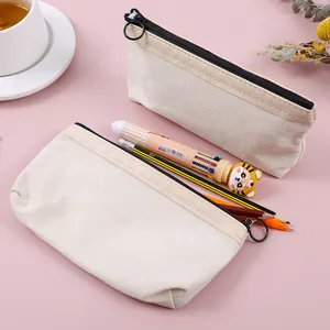 Detailansicht beige Segeltuch-Federtaschen mit schwarzen Reißverschlüssen und Metallringen