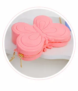 Primer plano de un bolso de mariposa rosa con cremallera dorada y cadena de metal