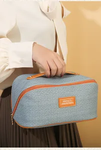 Detailansicht der gewebten blauen Kosmetiktasche mit Ledergriff und Aufnäher