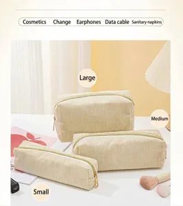 Set di tre eleganti borse per cosmetici in velluto a coste crema nelle taglie L, M e S.