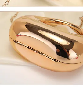 Primo piano di una pochette a mezzaluna in oro rosa metallizzato con dettagli lucidi