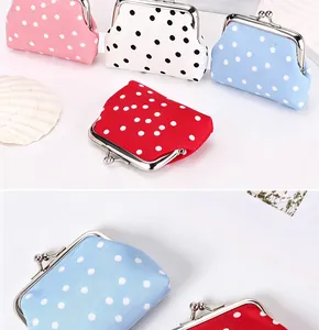 Detail der süßen Polka-Dot-Muster und des klassischen Metall-Klippverschlusses der Mini-Börsen