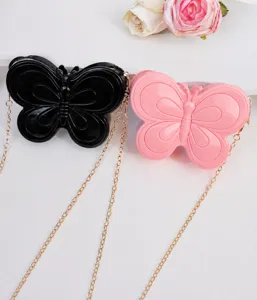 Vista detallada de bolsos mariposa de PVC con correas de cadena dorada elegante.