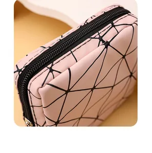 Detailansicht der rosa Aufbewahrungstasche mit schwarzem geometrischem Muster und Reißverschluss.