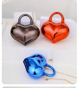 Tre borse colorate a cuore in acrilico lucido con catene dorate mostrate in ogni dettaglio