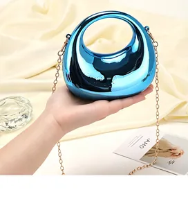 Dettaglio della pochette blu metallizzato a forma di mezzaluna con catena oro