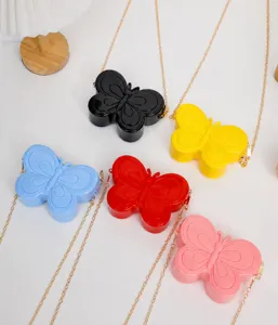 Detalle de lindos bolsos de gelatina de mariposa con cadenas doradas para niñas