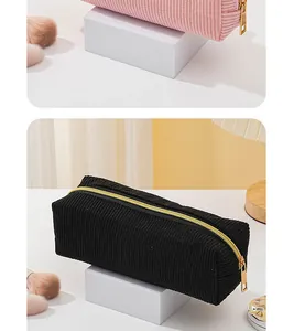 Detailansicht der weichen Kordstruktur und des goldenen Reißverschlusses der Tasche.