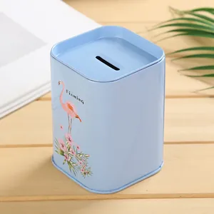 Vista detallada de una hucha metálica azul con diseño de flamenco rosa y flores