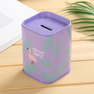Primer plano de una hucha cuadrada de metal púrpura con diseño de flamenco y hojas de palma