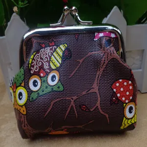 Vue détaillée du motif de hibou coloré sur un porte-monnaie à fermoir baiser texturé marron.