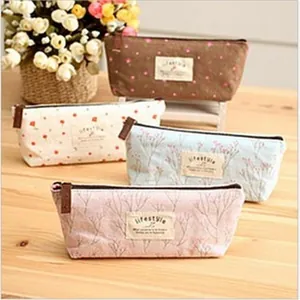 Set aus vier charmanten Federmäppchen aus floralem Canvas mit Lifestyle-Labels auf Holzoberfläche