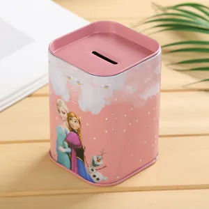 Primer plano de una hucha cuadrada de hojalata rosa con estampado de dibujos