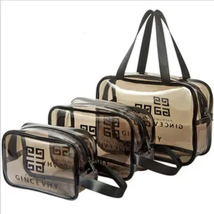 Detailansicht eines dreiteiligen Sets brauner transparenter PVC-Kulturbeutel mit Griffen