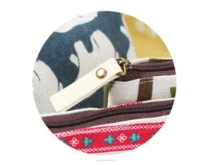 Close-up of vintage canvas coin purse zipper with white pull tab and patterned fabric.