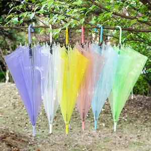 Set aus bunten, halbtransparenten Regenschirmen, die im Freien an einem Ast hängen
