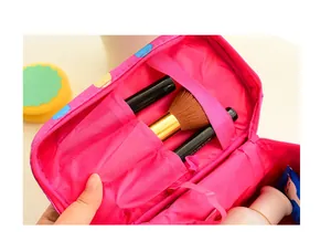 Detailopname van interne vakken en penseelhouders van de roze make-up toilettas