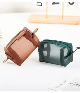 Detail view of two mini square mesh pouches in brown and green for coins and earphones
