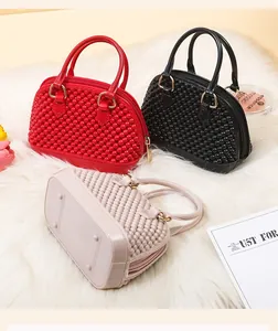 Detailed view of three mini PVC jelly shell handbags in red, black, and beige colors