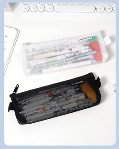 Nahaufnahme von minimalistischen schwarzen und weißen Netz-Federmäppchen mit Inhalt.