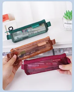 Drie kleurrijke vintage mini mesh pennenzakken voor studenten in de hand gehouden voor schaal