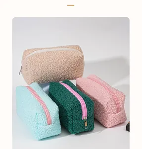 Macro detail of plush lamb wool cosmetic bags in various pastel colors with zippers