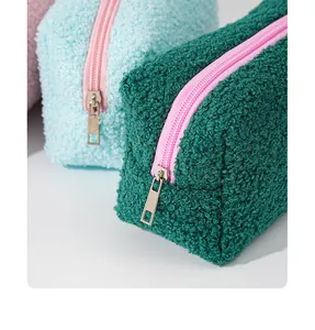 Close-up macro view of fluffy teddy fleece cosmetic bag with pink zipper and metal pull